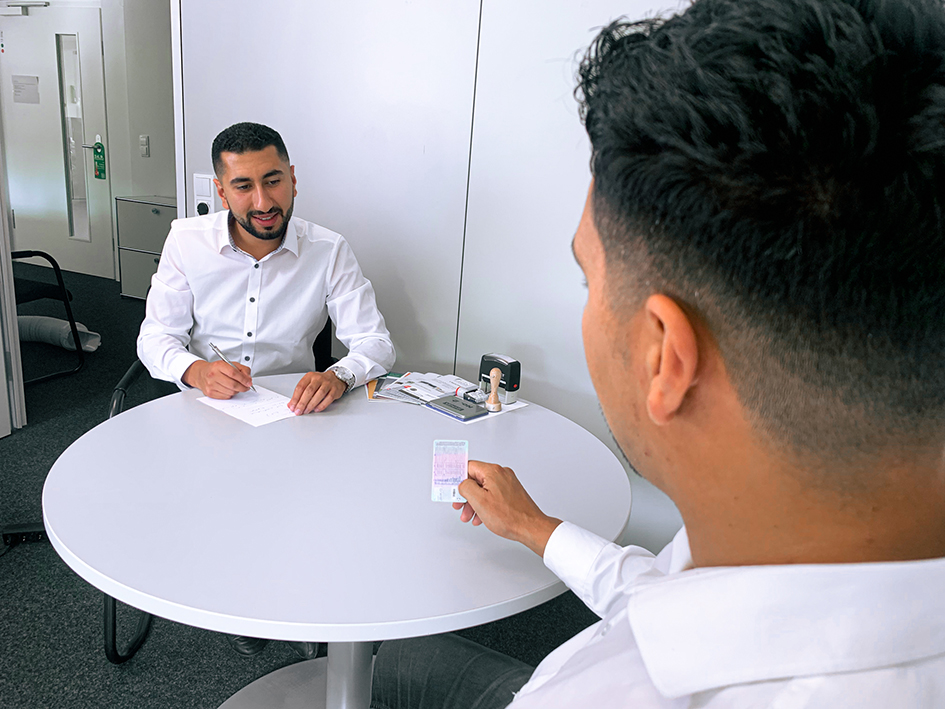 Khalid und Ibrahim Elouhabi mit Führerschein am Tisch